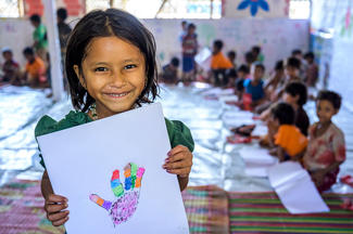 Ein Rohingya-Mädchen zeigt seine Zeichnung im World Vision-Kinderzentrum in Bangladesch