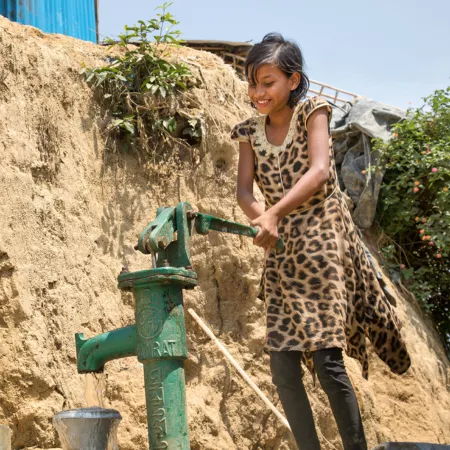 Mädchen holt frisches Wasser für die Familie.